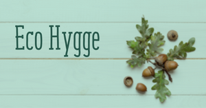 Cyan image with acorns to the right and the text eco hygge in green to the left 